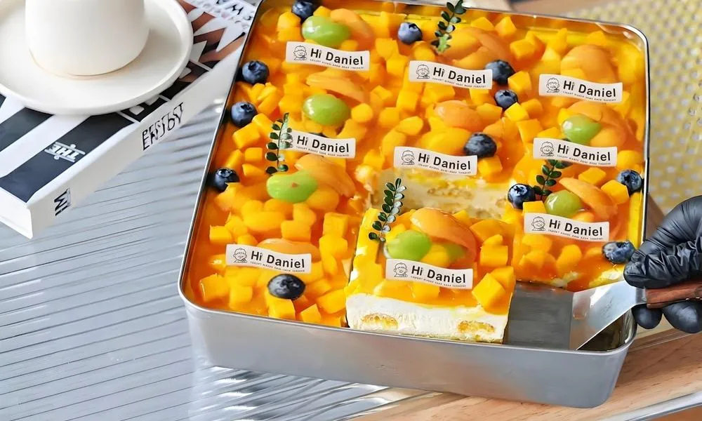 Hi Daniel Mango Cake A colorful mango cake with fresh fruit toppings at Hi Daniel, a Dessert Shop restaurant in Tukwila